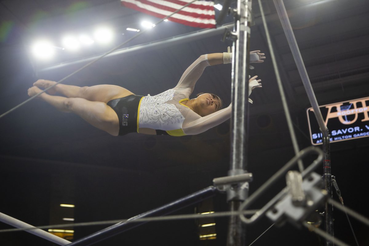 Gymnast Aurelie Tran moves to the high bar during the Iowa Gymnastics senior night at Carver-Hawkeye Arena on March 7, 2025. Tran scored a 9.950 on the uneven bars.