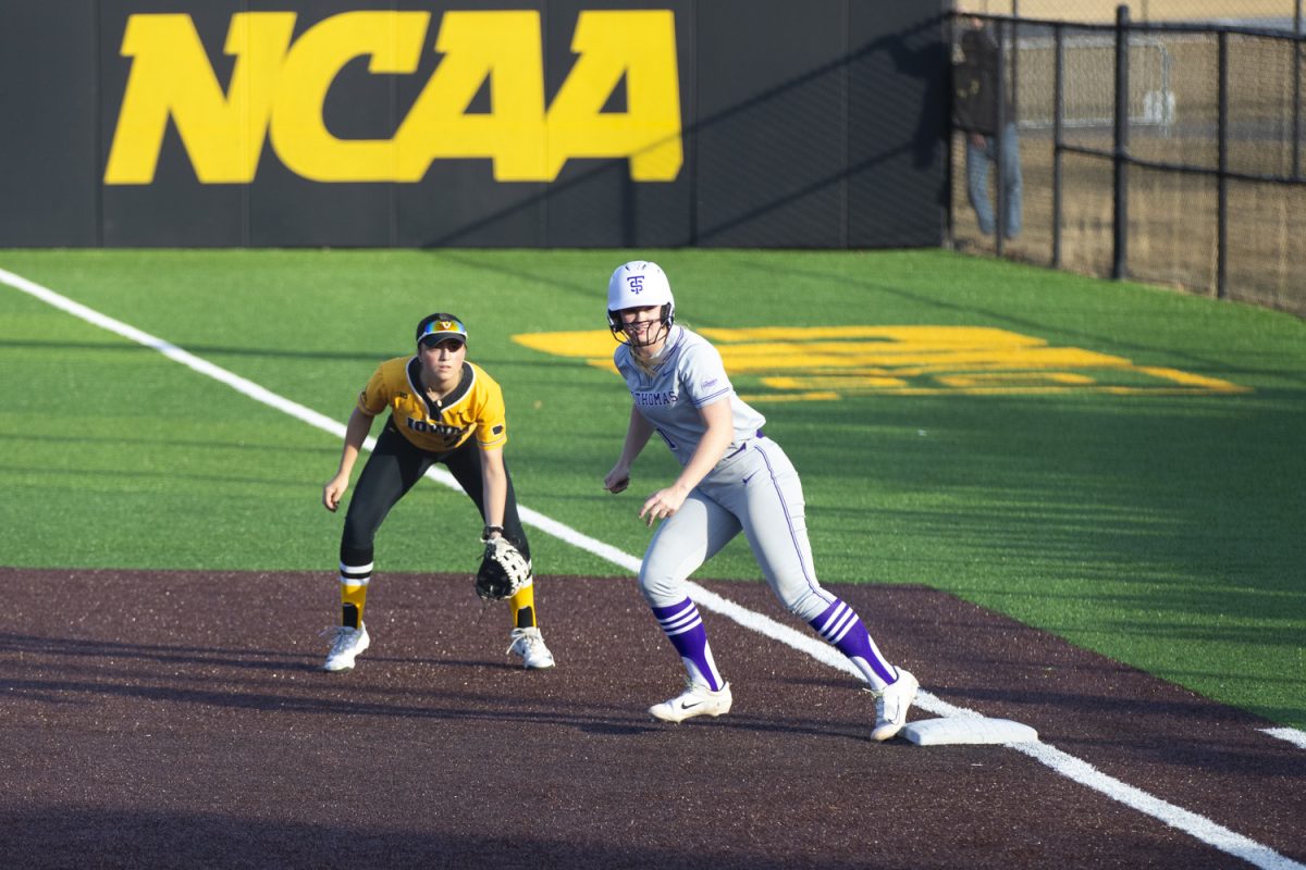 Iowa infielder Brianna Johnson waits for the pitch while Thomas shortstop Laken Lienhard pushes off first base during a women's softball game between Iowa and St. Thomas at Bob Pearl Softball Field in Iowa City on Mar. 12, 2025. The Hawkeyes defeated St. Thomas, 1-0.