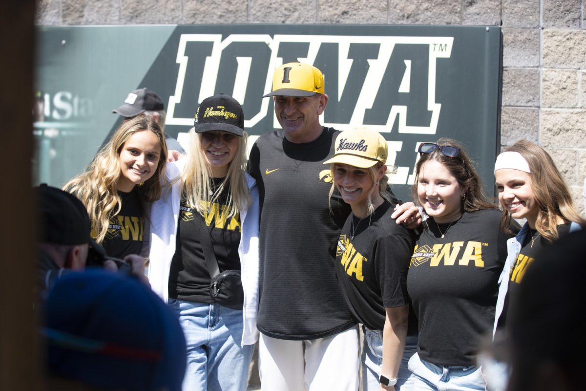 Iowa baseball head coach Rick Heller poses with tailgate attendees at Duane Banks Field during a tailgate hosted by the Hawks Nest on Saturday, April 12, 2025.