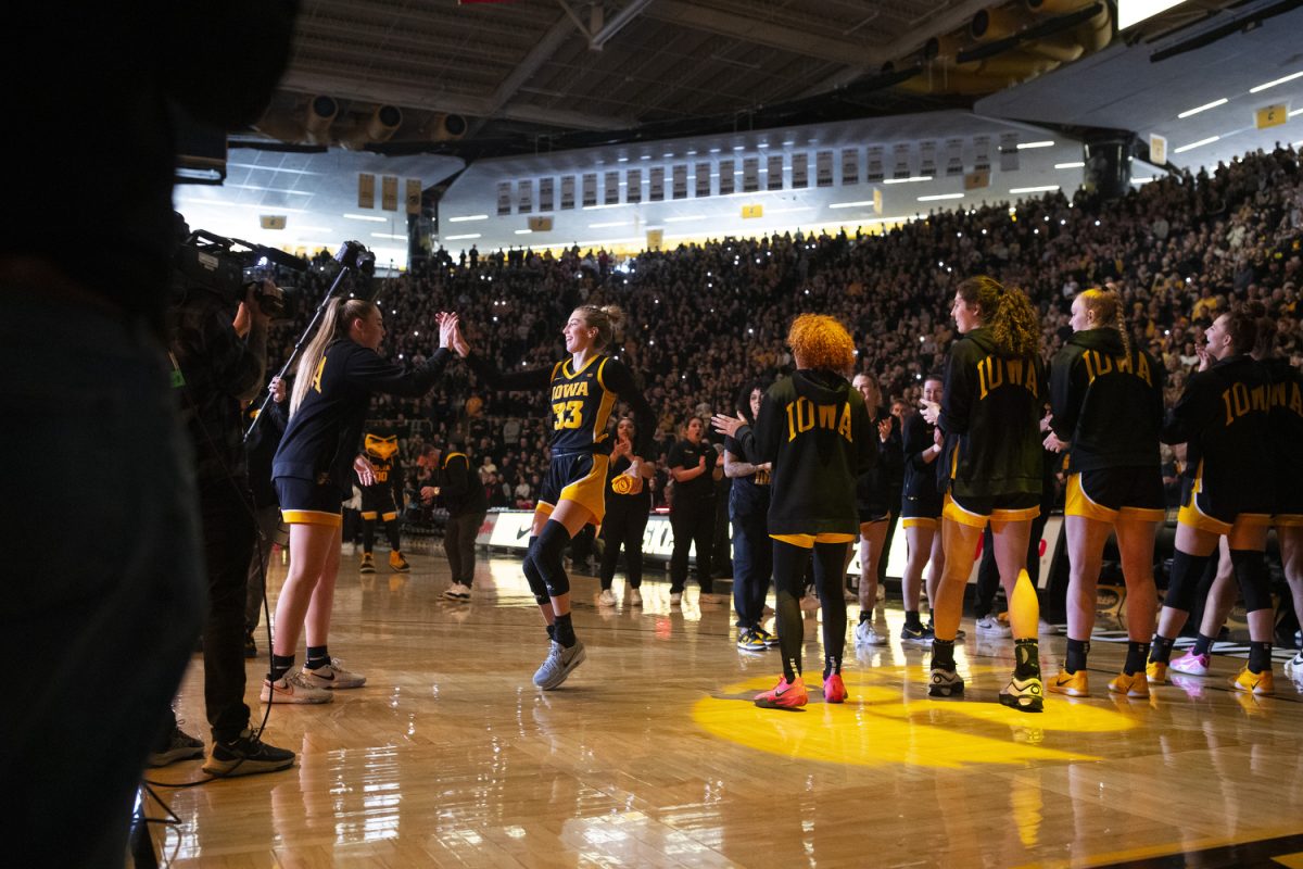 Iowa guard Lucy Olsen high fives Iowa forward AJ Ediger after being announced before a women's basketball game between Iowa and Wisconsin at Carver-Hawkeye Arena in Iowa City on Sunday, March. 2, 2025. The Iowa Hawkeyes defeated the Wisconsin Badgers 81-66.