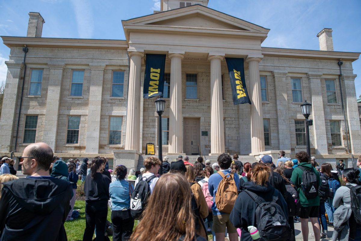 Protestors hold up posters and listen to Christopher Merrill, the director of the International Writing Program, during the Teach-In &amp; Speak Out event at the Pentacrest on Thursday, April 17, 2025. The protest was organized by the American Association of University Professors, COGS, and Standing Up For Science, and featured speakers who discussed the importance of free speech in education and the safety of international students.