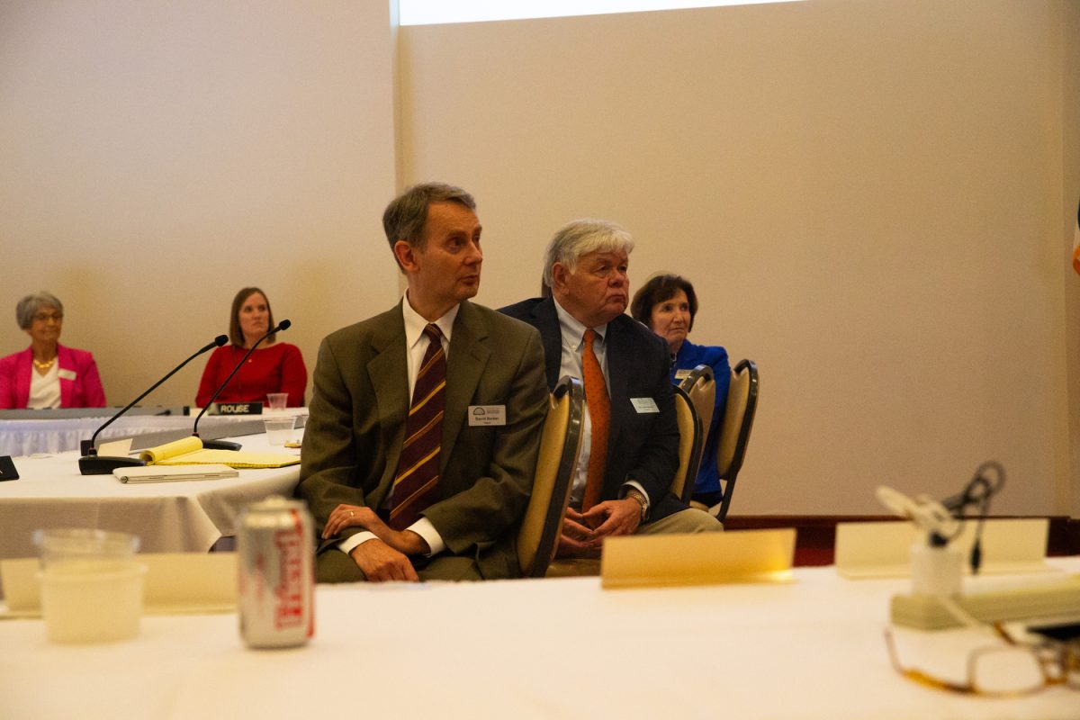 Regents David Barker and Jim Lindenmayer listen to protesters during a board meeting in Ames, Iowa on April 23, 2025.