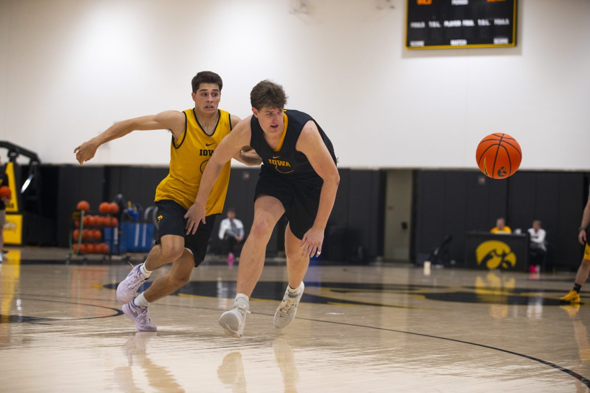 Peyton McCollum and Trevin Jirak run towards the ball during an Iowa mens basketball practice at Carver-Hawkeye Arena on Thursday June 19, 2025.