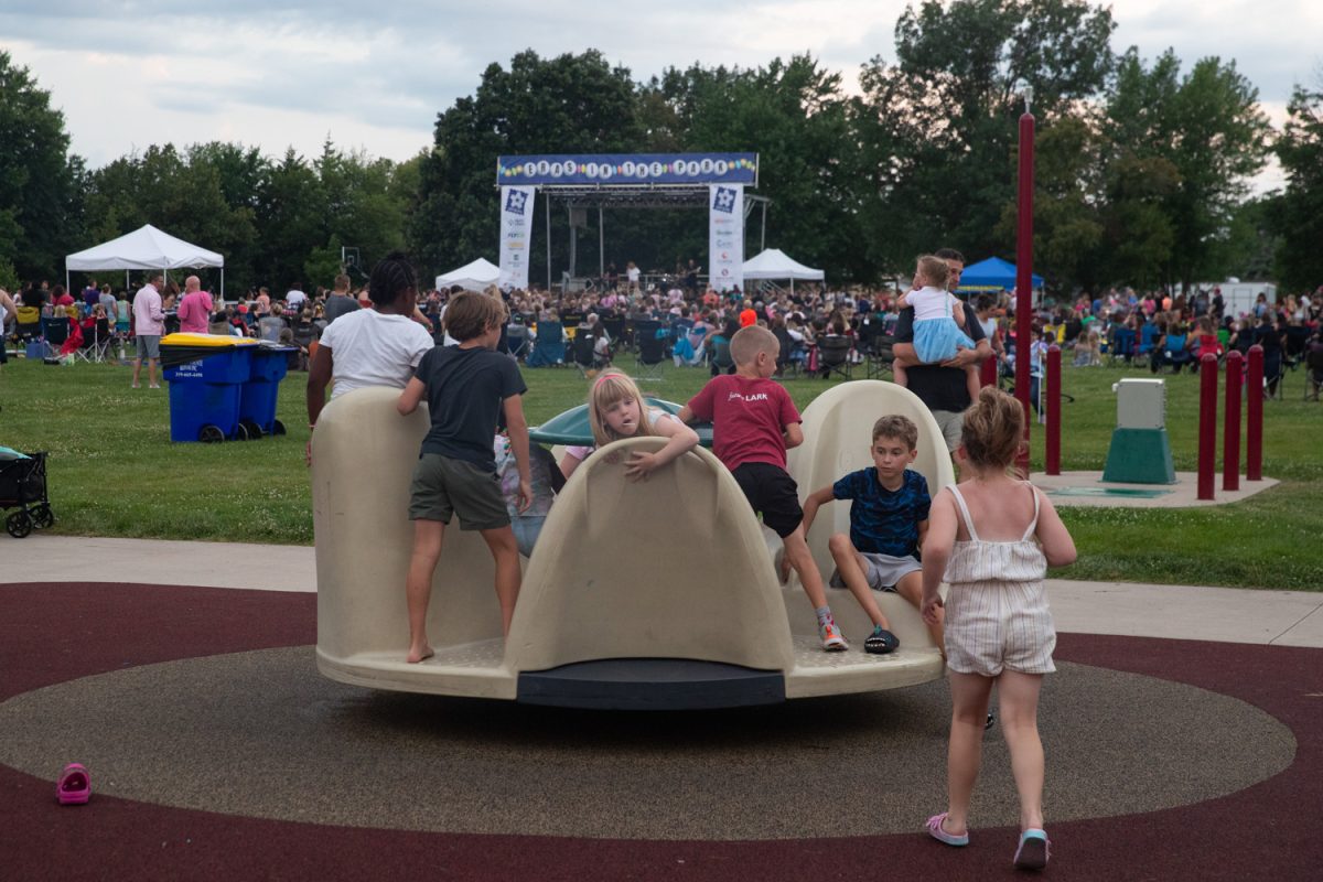Children play on the playground during Eras in the Park: a Free Taylor Swift Tribute in Penn Meadows Park, North Liberty, on Thursday, July 10, 2025. Attendees made and swapped bracelets, ordered food from local vendors, and took photos before the cover band Swift Nation Tribute performed for a little over an hour.