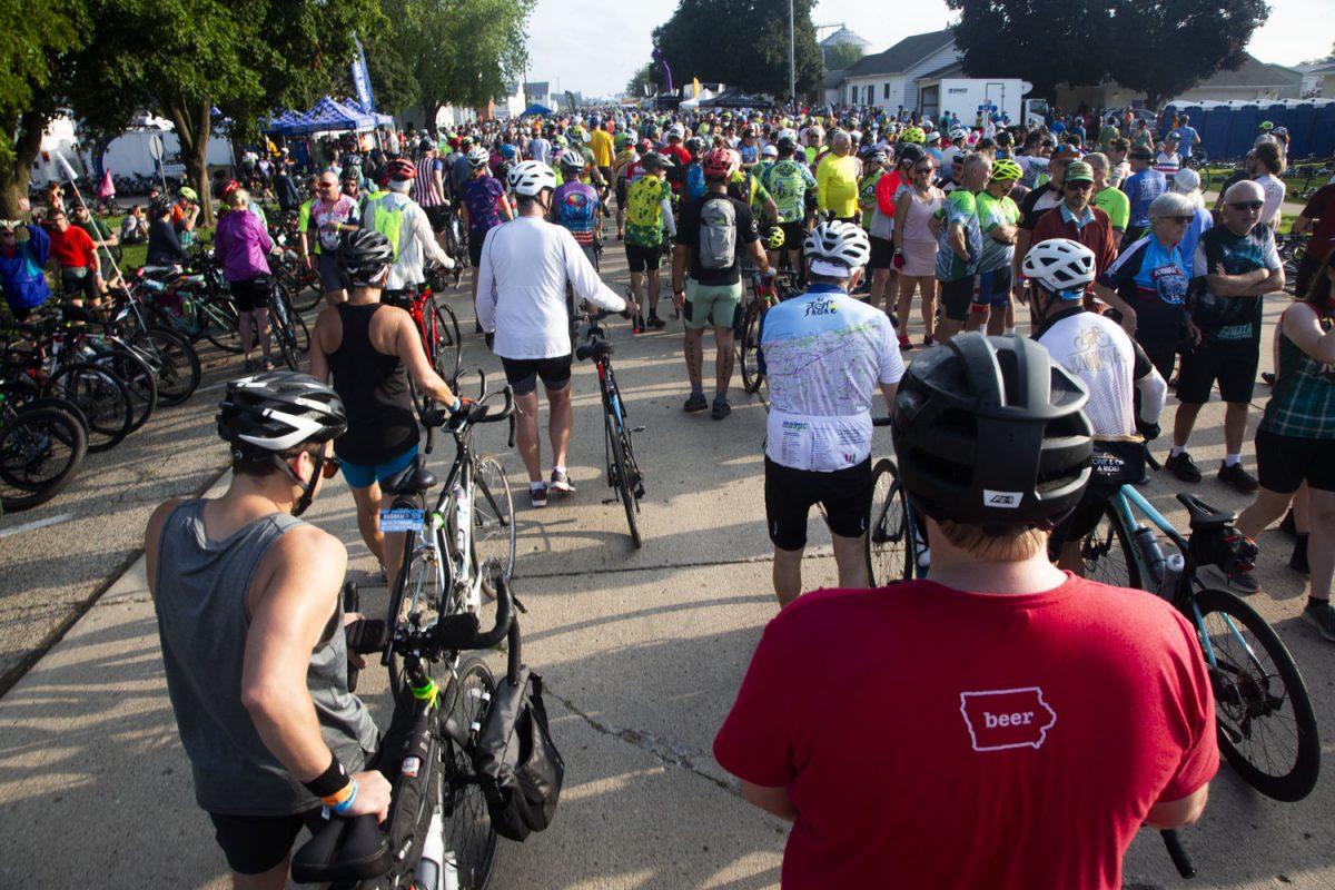 Riders walk with their bicycles past food vendors and bicycle repair stands through Granville, IA on Sunday, July 20, 2025. Pass through towns for RAGBRAI LII’s Sunday route include Granville, Primghar, Hartley, and May City, IA.