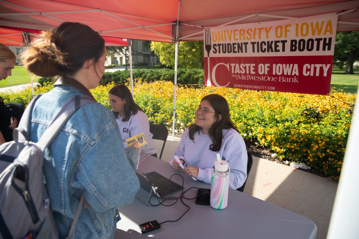 Students receive tickets at the Taste of Iowa City event on Wednesday, Aug. 27, 2025. The free tickets were sold out after an hour, with over a hundred students and community members exchanging tickets for meals at restaurant stands downtown.
