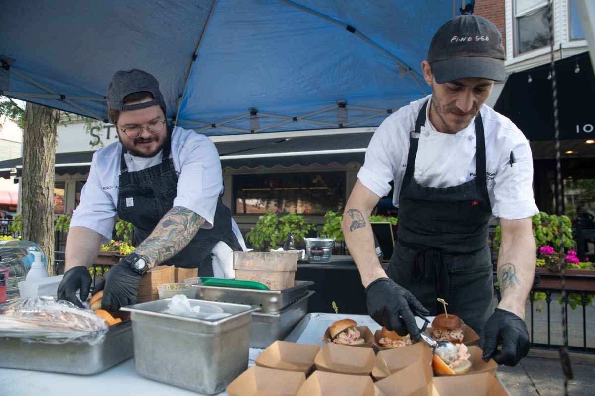 Servers at the Saint Burch Tavern make lobster burgers at the Taste of Iowa City event on Wednesday, Aug. 27, 2025. The free tickets were sold out after an hour, with over a hundred students and community members exchanging tickets for meals at restaurant stands downtown.