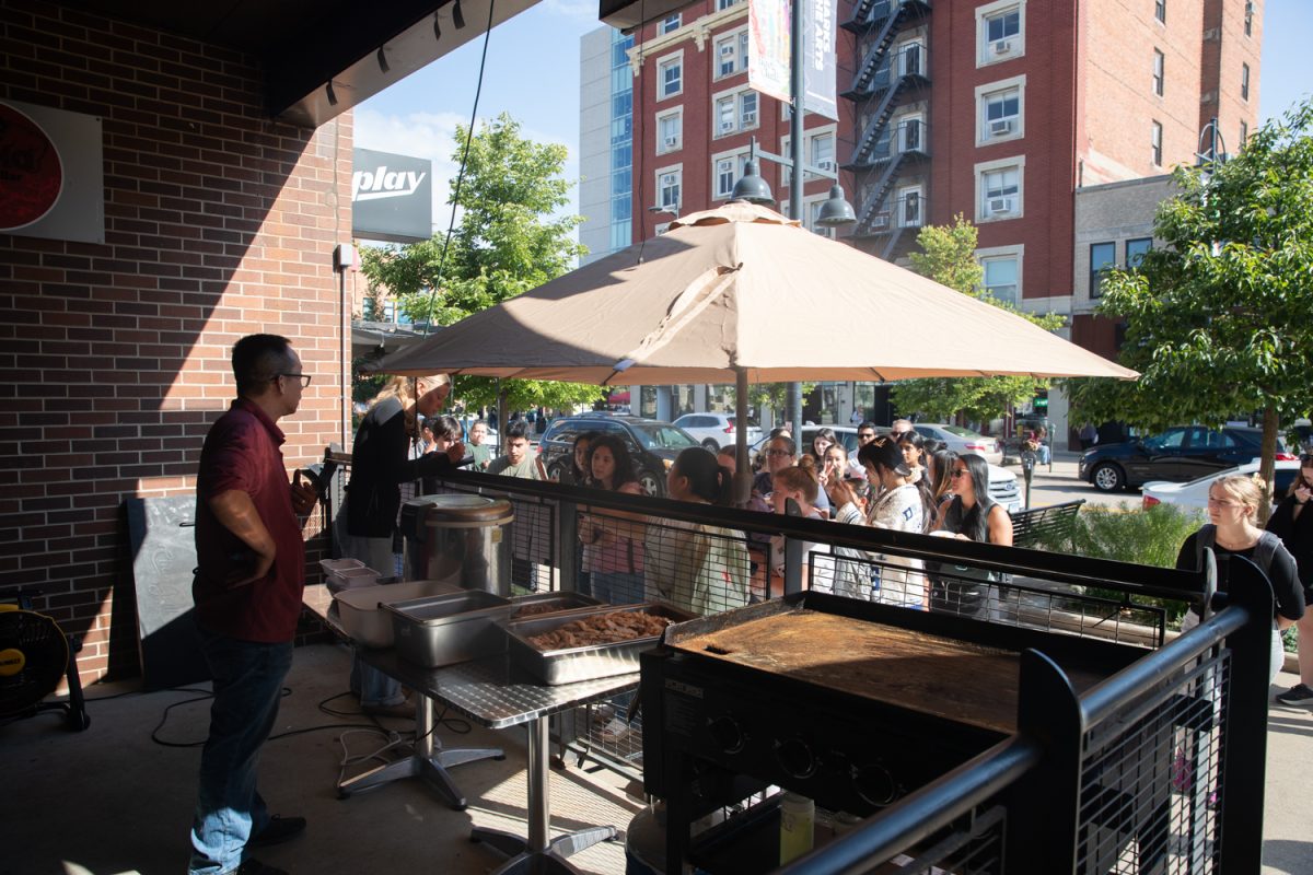 Customers wait in line for Sumo Sushi at the Taste of Iowa City event on Wednesday, Aug. 27, 2025. The free tickets were sold out after an hour, with over a hundred students and community members exchanging tickets for meals at restaurant stands downtown.
