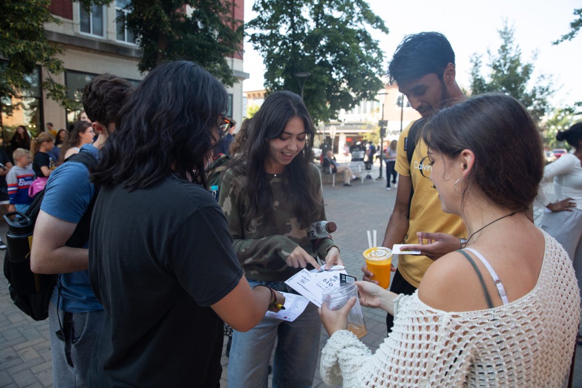 A group plans their next location during the Taste of Iowa City event on Wednesday, Aug. 27, 2025. The free tickets were sold out after an hour, with over a hundred students and community members exchanging tickets for meals at restaurant stands downtown.