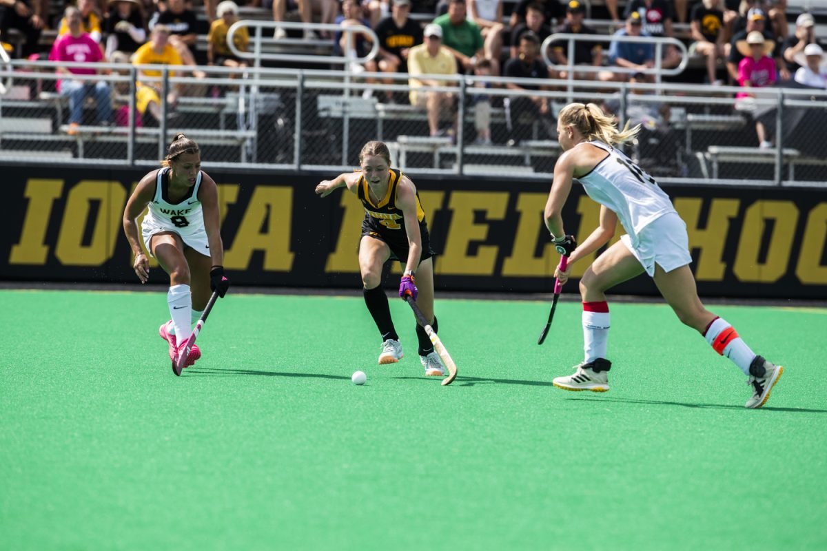Iowa midfielder Niamh De Jong moves between Wake Forest midfielders Ava Moore and Faye Janse during a field hockey game between No. 15 Iowa and No. 20 Wake Forest at Grant Field in Iowa City on Friday, Aug. 29, 2025. The Hawkeyes defeated the Demon Deacons 5-4.