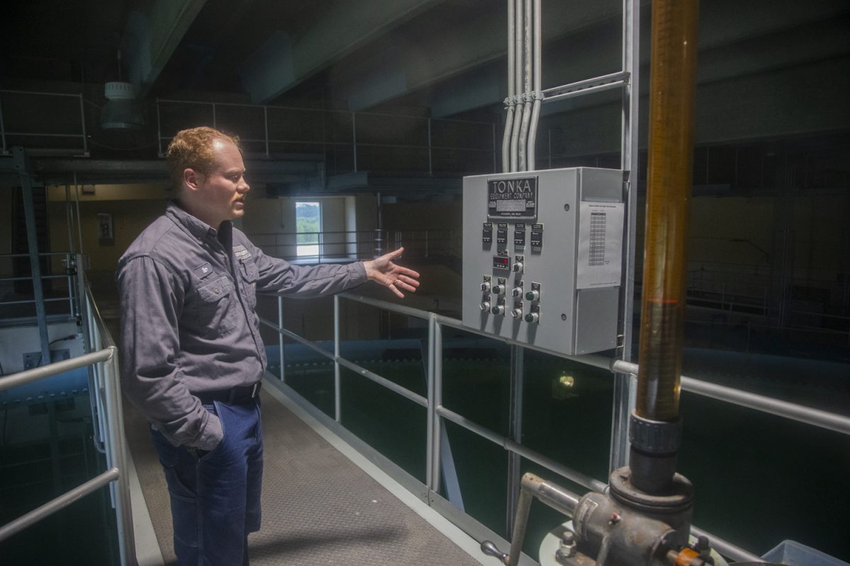 Senior Treatment Plant Operator Sam Fosse gestures to a control panel above a water clarifier inside of the Iowa City Water Purification building in northern Iowa City on Wednesday, Aug. 27, 2025. The clarifier is completely hydraulic, utilizing the flow of water into the basin to govern speed of spin.