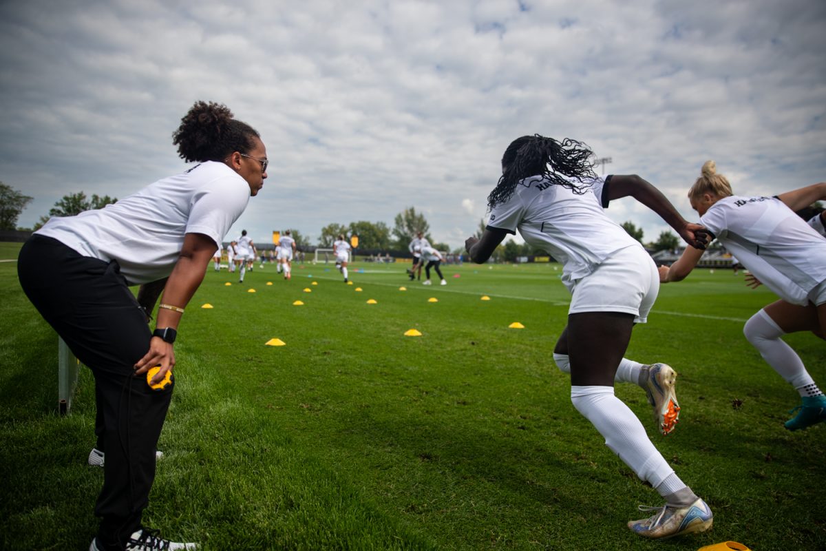 Assistant strength and conditioning coach Mariah Cook guides Iowa soccer players through a warm up before an Iowa soccer game against Western Michigan at the Iowa Soccer Complex in Iowa City on Sunday, Aug. 31, 2025. Cook started working at the University of Iowa in July and works with the women’s soccer, women’s tennis, women’s golf and cross country teams. Before she came to the University of Iowa, the Michigan native was an Assistant Director of Athletic Performance at the University of Missouri.