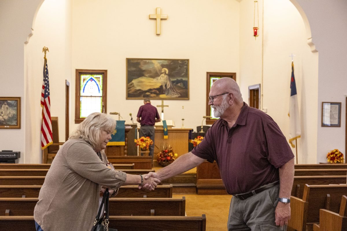 Pastor Dave Peterson shakes Marcia Barker’s hand following a service at Batavia United Methodist Church in Batavia, Iowa, on Sept. 20. On an average day of attendance, the congregation numbers 17 people.