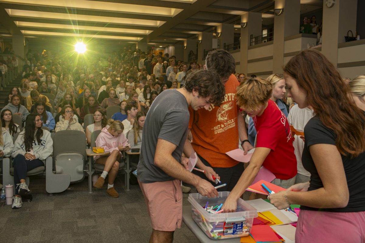 Club members gather markers and cards during a club meeting of Letters of Love in Tippie College of Business in Iowa City on Monday, Oct. 13, 2025. Over a hundred members gather at each meeting to write letters of support to children with cancer. The organization raised $1,774.57 with custom club hoodies, which were distributed at the meeting.