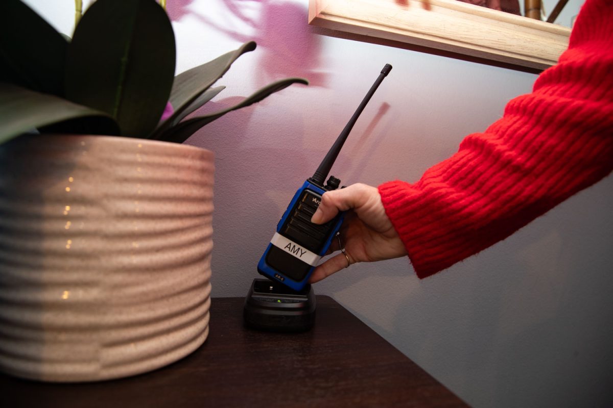 Amy Hospodarsky lifts up her walkie talkie at Crowded Closet in Iowa City on Monday, Oct. 27, 2025. Hospodarsky is running from Iowa City Council this upcoming election, and has worked as director at the Crowded Closet for the past year because “It’s a mesh of all the causes I’m interested in.”