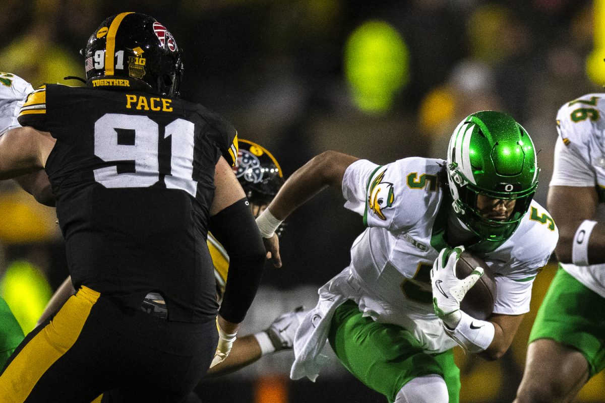 Oregon quarterback Dante Moore weaves past defenders during a football game between the No. 20 Iowa Hawkeyes and the No. 9 Oregon Ducks at Kinnick Stadium in Iowa City, Iowa on Saturday, Nov 8, 2025. The Ducks defeated the Hawkeyes 18-6. Moore had 21 passing attempts during the matchup.