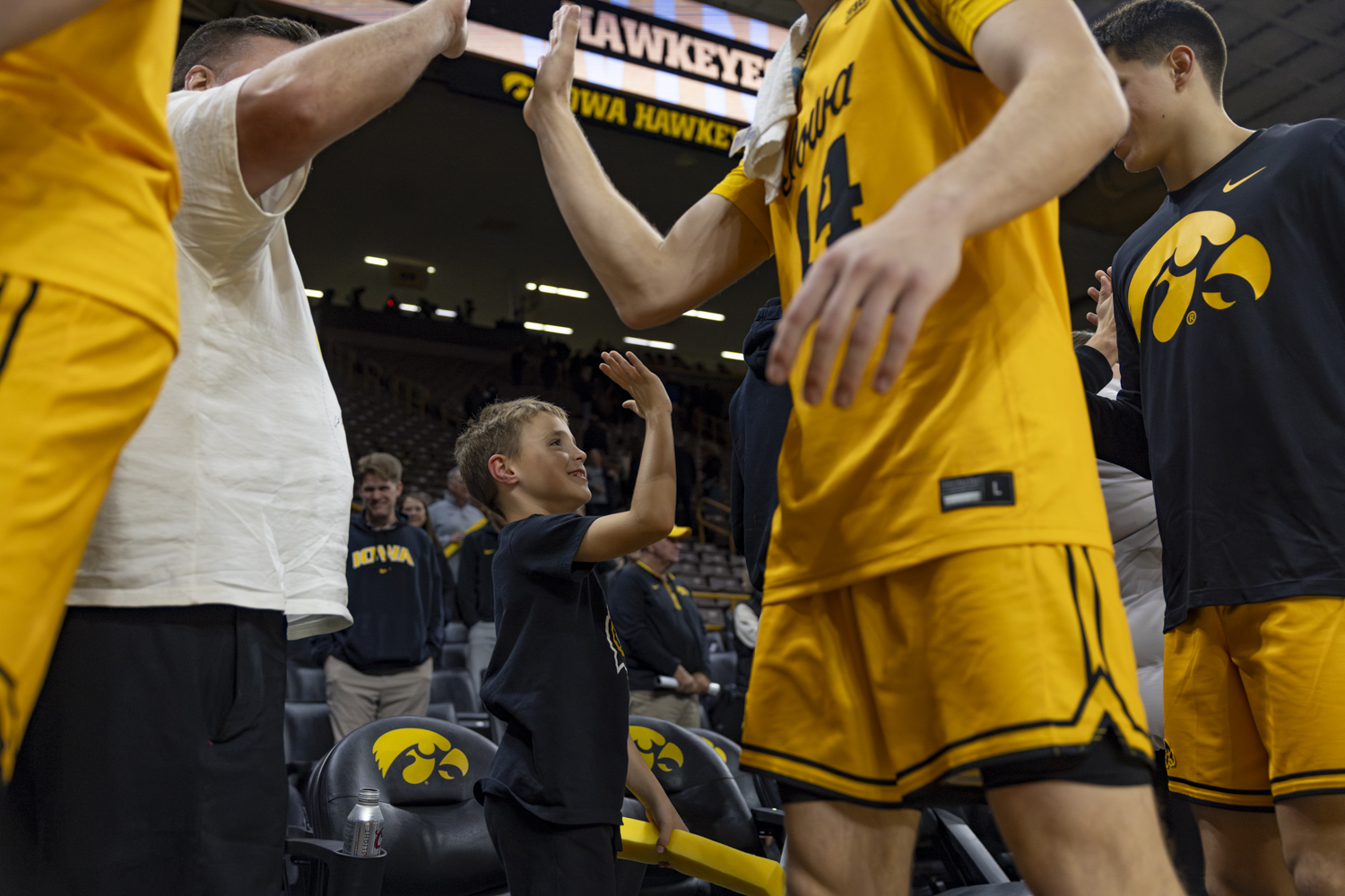 Iowa players high-five a young fan during a basketball game between the Iowa Hawkeyes and the Southeast Missouri State Redhawks at Carver-Hawkeye Arena on Thursday, Nov. 18, 2025. The Hawkeyes defeated the Redhawks 99-70.