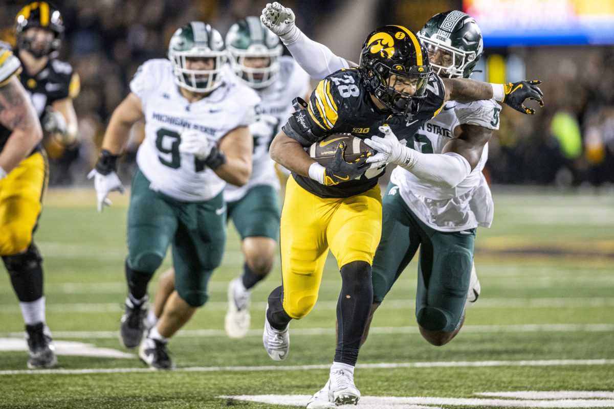 Iowa running back Kamari Moulton tries to break Michigan State defensive lineman Jalen Thompson during a football game between Michigan State and Iowa at Kinnick Stadium on Nov. 22, 2025. Moulton had 78 rushing yards. The Hawkeyes defeated the Spartans 20-17.
