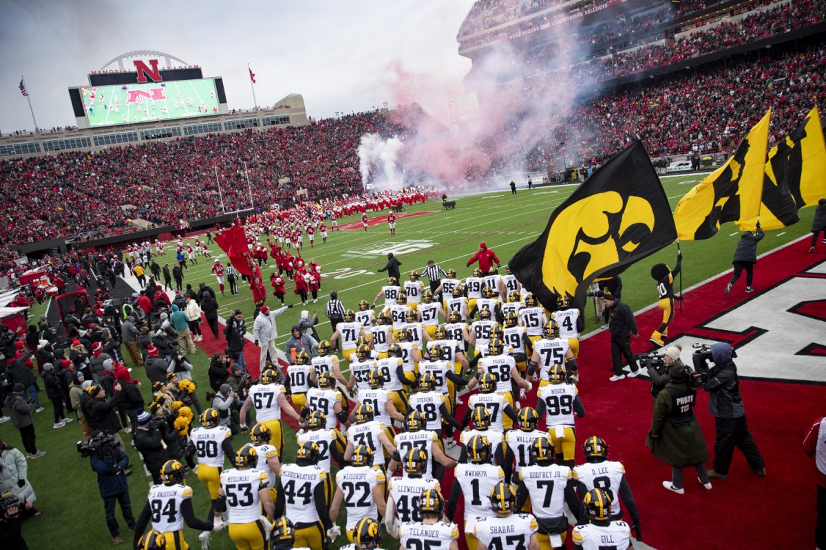 Iowa players swarm the field before a football game between Iowa and Nebraska at Memorial Stadium in Lincoln, Nebraska on Friday, Nov. 28, 2025. The Hawkeyes defeated the Cornhuskers 40-16.