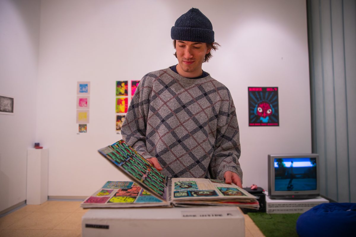 Bodie Williamson, artist and creator of the How Lucky: BFA Exhibition, flips through pages of hand drawn sketches in the Visual Arts Building in Iowa City, Iowa on Wednesday, Dec. 3, 2025. Williamson is an emerging artist at the University of Iowa who has participated in the Summer of Arts Festival.