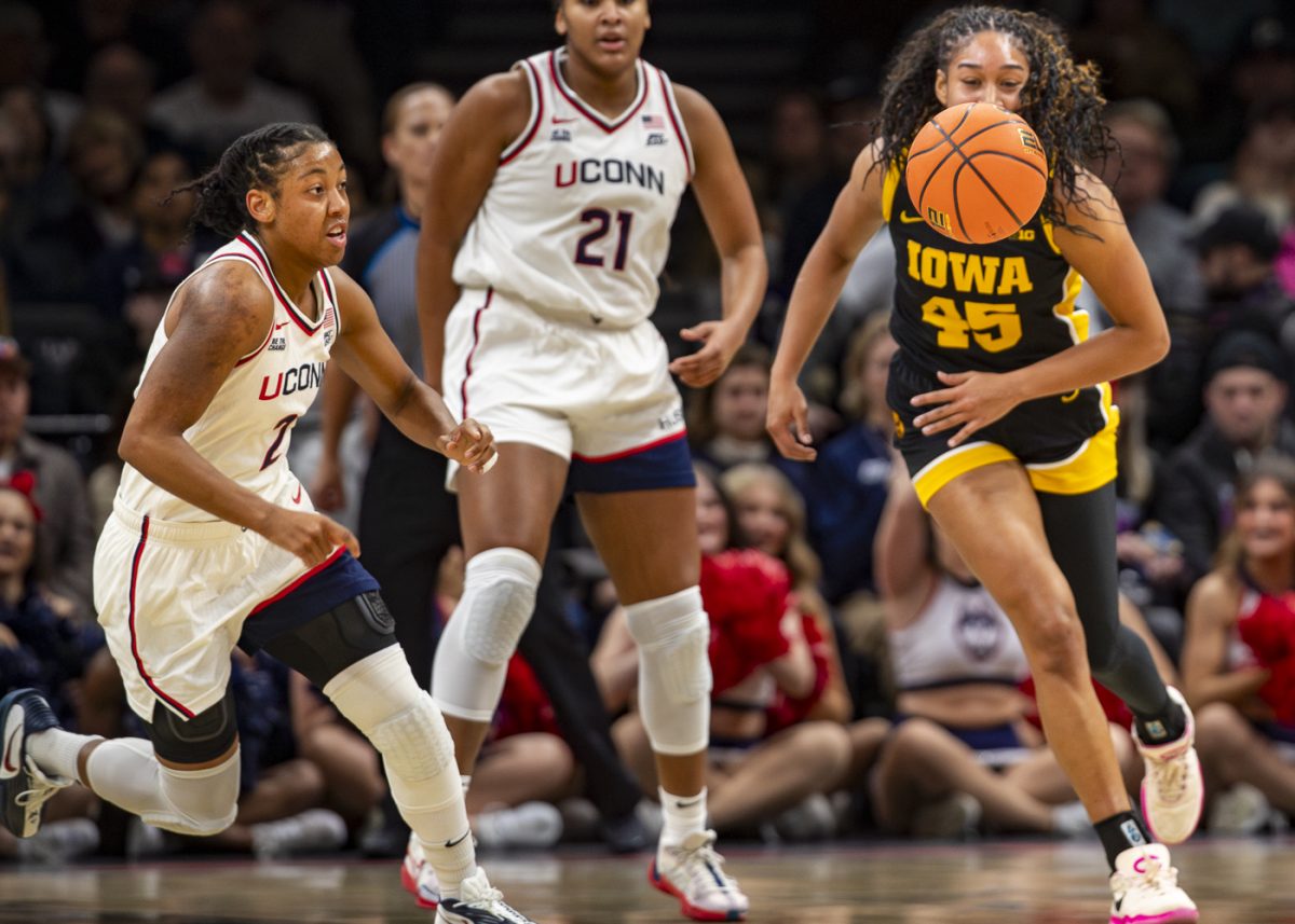UConn guard KK Arnold and Iowa forward Hannah Stuelke chase after the ball during a basketball game between the Iowa Hawkeyes and the UConn Huskies at the Barclays Center in Brooklyn, NY on Saturday, Dec. 20, 2025. The Huskies defeated the Hawkeyes 90-64. Stuelke scored 17 points. (Emma Calabro/The Daily Iowan)
