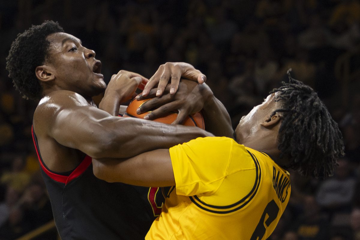 Maryland forward Pharrel Payne and Iowa guard Tavion Banks fight over the ball during a basketball game between the Iowa Hawkeyes and the Maryland Terrapins at Carver-Hawkeye Arena on Saturday, Dec. 6, 2025. The Hawkeyes defeated the Terrapins 83-64.