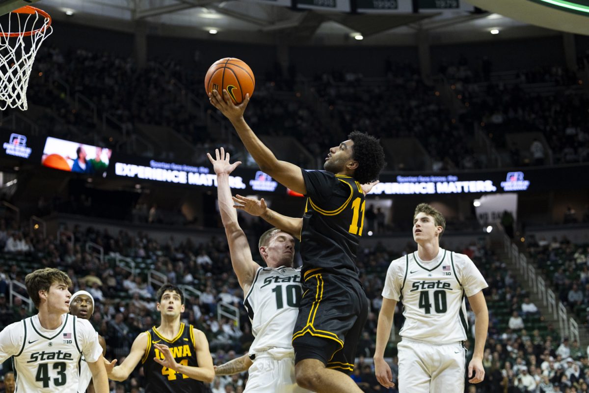 Michigan State guard Denham Wojcik attempts to block a layup from Iowa guard Kael Combs during a basketball game between the Iowa Hawkeyes and the Michigan State Spartans at the Jack Breslin Student Events Center in East Lansing, Michigan on Tuesday, Dec. 2, 2025. Combs added four points. The Spartans defeated the Hawkeyes 71-52.