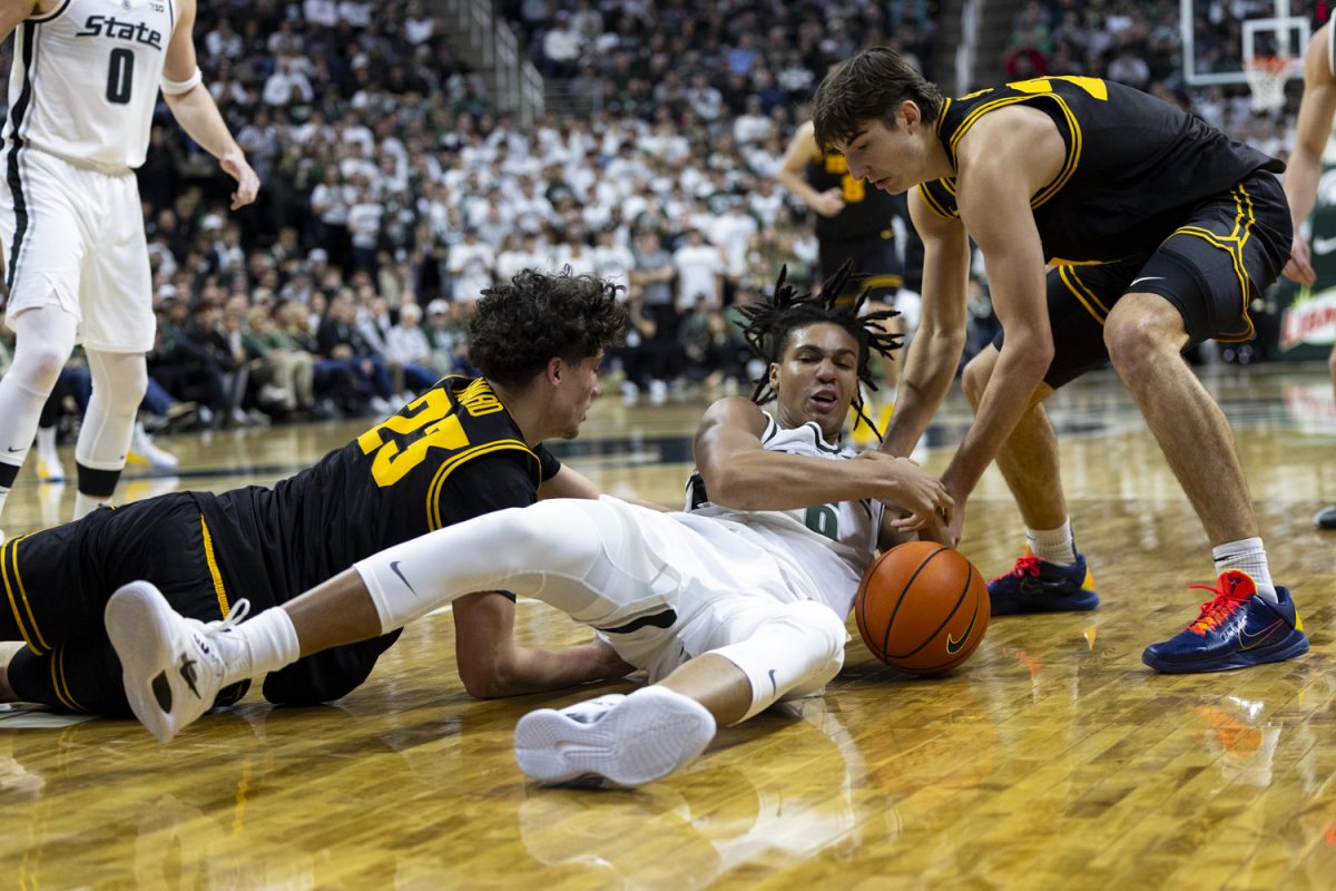 Michigan State forward Jordan Scott attempts to grab the ball from the Iowa offense during a basketball game between the Iowa Hawkeyes and the Michigan State Spartans at the Jack Breslin Student Events Center in East Lansing, Michigan on Tuesday, Dec. 2, 2025. Scott added six points. The Spartans defeated the Hawkeyes 71-52.