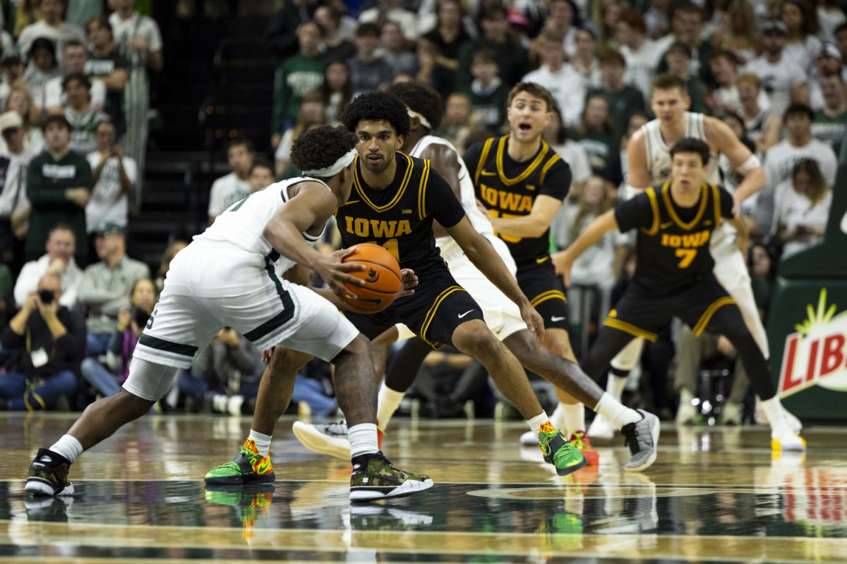 Iowa guard Kael Combs faces off against a Michigan State player during a basketball game between the Iowa Hawkeyes and the Michigan State Spartans at the Jack Breslin Student Events Center in East Lansing, Michigan on Tuesday, Dec. 2, 2025. The Spartans defeated the Hawkeyes 71-52.