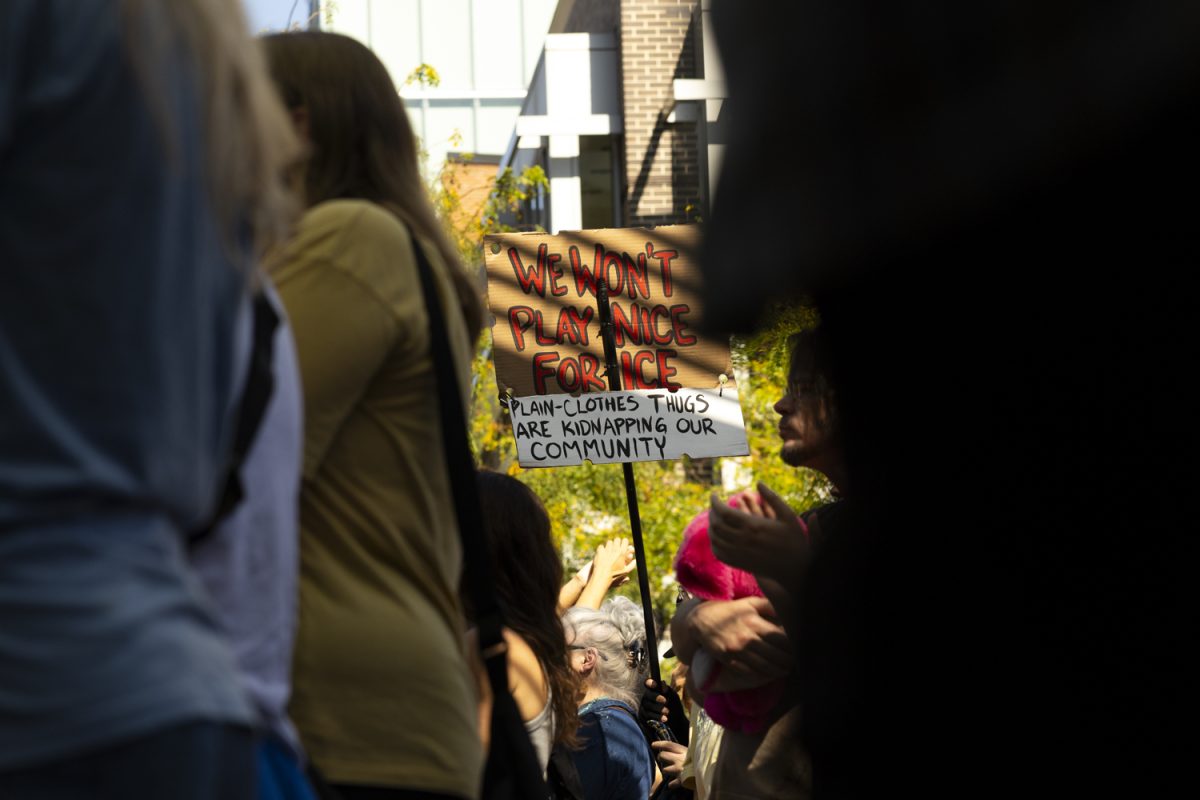 A sign is held up by a community member during a rally at the Pedestrian Mall in Iowa City, Iowa, on Friday, Sept. 26, 2025. 