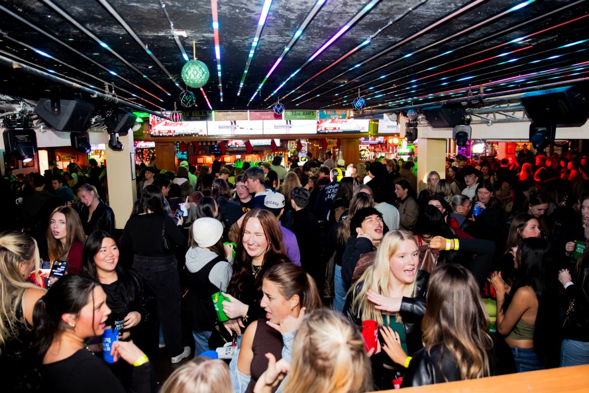 Bargoers dance and talk on the dance floor at Brothers during Mug Club on Thursday, Dec. 11, 2025.
