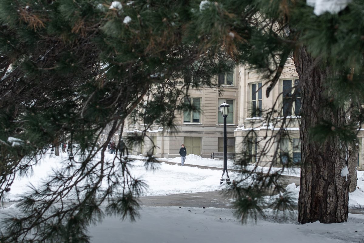 A college student walks along McBride Hall in Iowa City, Iowa on Monday, Dec. 1, 2025. 