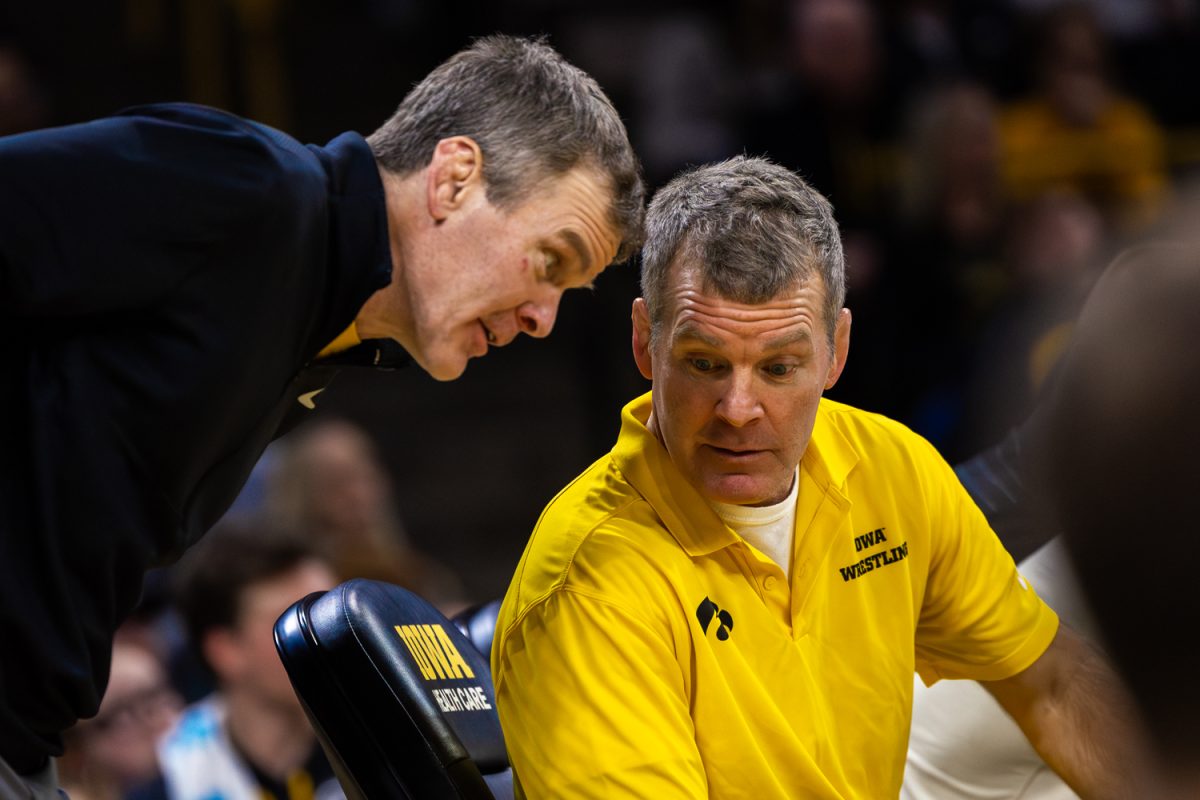 Iowa Assistant coach Terry Brands whispers to Iowa Head coach Tom Brands during a Big10 top-five wrestling dual between the No. 4 Iowa Hawkeyes and the No. 1 Penn State Nittany Lions at Carver-Hawkeye Arena in Iowa City, Iowa on Friday, Jan. 16, 2026. (Reece Schrader/The Daily Iowan)