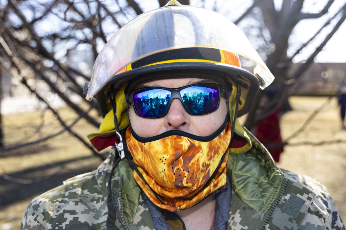 Bettendorf resident Pekc Grove poses for a portrait during a protest against ICE at the University of Iowa Pentacrest on Sunday, Jan. 25, 2026, following the second fatal shooting in Minneapolis by a U.S. Immigration and Customs Enforcement (ICE) officer this month. The helmet worn by Grove is from the Euromaidan protests in Ukraine in late 2013 and early 2014. (Samantha DeFily/The Daily Iowan)