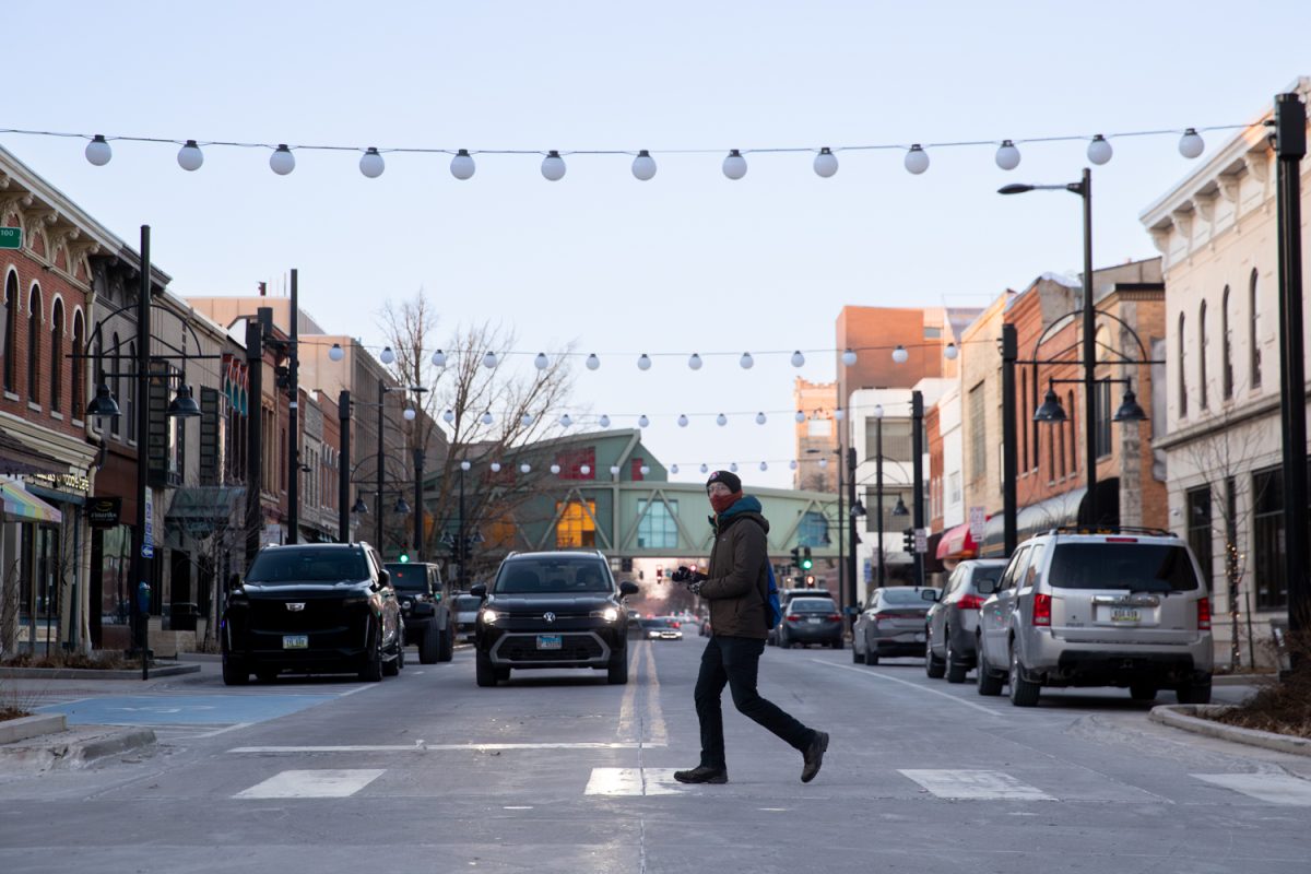 A pedestrian is seen crossing Dubuque street in downtown Iowa City on Sunday, Jan. 25, 2025. The Downtown District recently voted to continue its Self-Supported Municipal Improvement District on Jan. 6. (Ethan McLaughlin/The Daily Iowan)