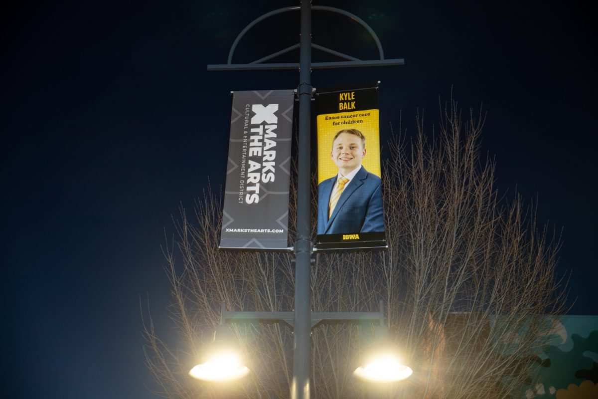 A poster of Kyle Balk is seen in Downtown Iowa City on Thursday, Jan. 29, 2026. Balk is one of 40 University of Iowa student researchers honored with a banner as part of the Dare to Discover campaign. Balk, from Davenport, worked in a radiation oncology lab to research children’s cancer cases. (Ava Neumaier / The Daily Iowan)