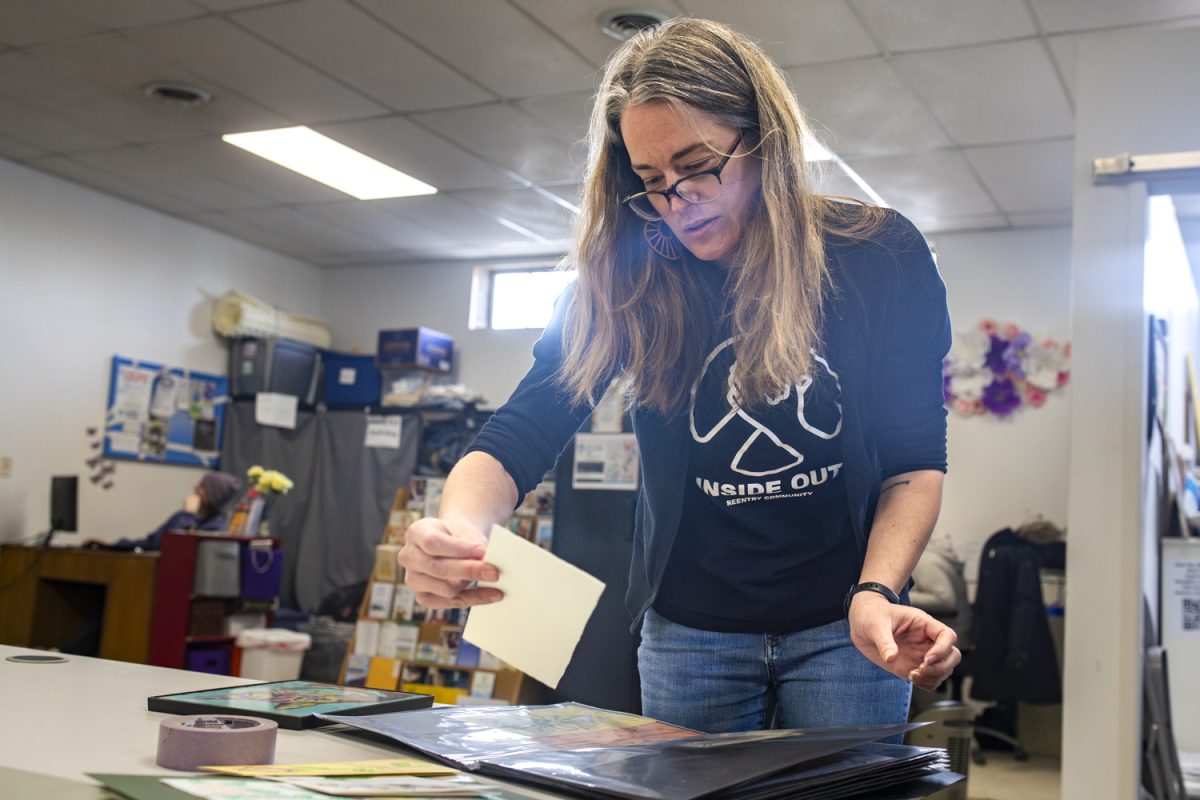 Michelle Heinz, executive director for Inside Out, sorts through artwork at Inside Out Reentry Community in Iowa City on Friday, Jan. 30, 2026. On Feb. 6 Public Space one will host an art show featuring work from incarcerated and formerly incarcerated people. (Emma Calabro/The Daily Iowan)