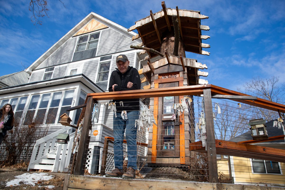 Joe Hennager poses for a portrait at the Iowa City Reading Tree on Tuesday, Feb. 3, 2026. Hennager built the library himself in his front yard over the COVID-19 pandemic. Made out of a fallen tree, the community library has books for all ages. “I want my children and grandchildren to enjoy it,” Hennager said. (Ava Neumaier / The Daily Iowan).
