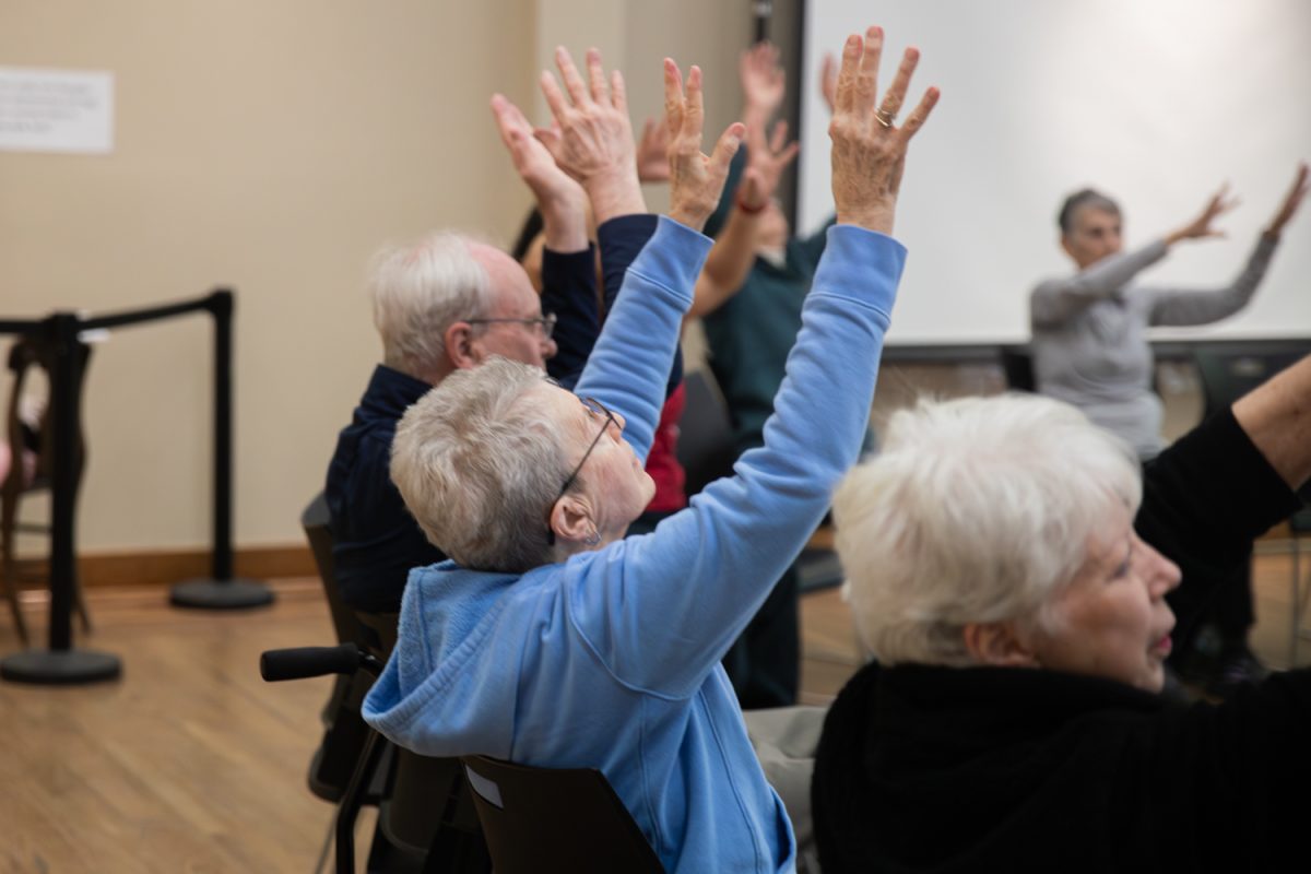 A participant follows the instructor’s movements during the "Dancing with Parkinsons" class at the senior center in Iowa City, Iowa, on Wednesday, Feb. 4th, 2026. The first half of the class was the sitting portion. (Andy Espineira/The Daily Iowan)