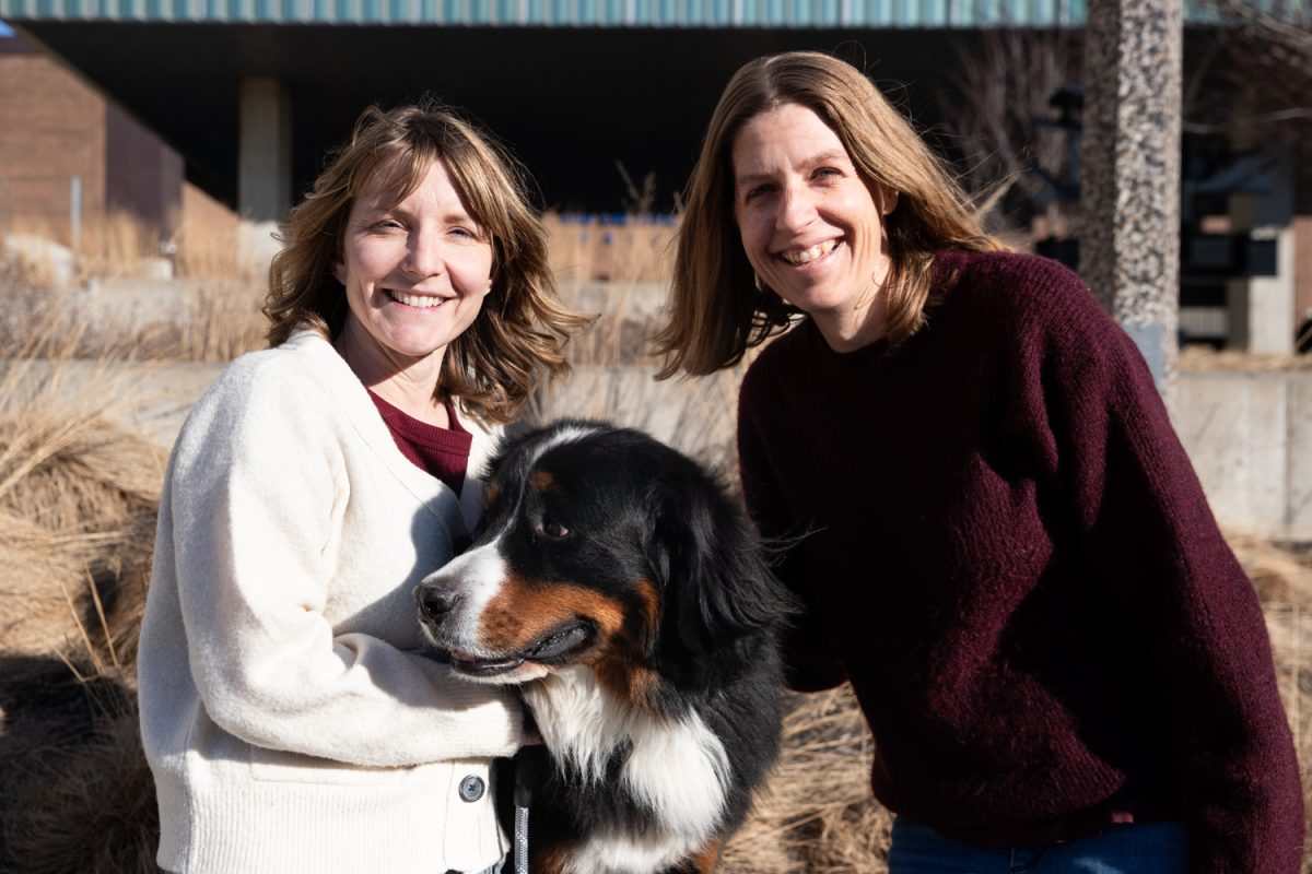 Adrienne Johnson, Katy Schroder, and therapy dog Drax pose for a portrait outside of the University of Iowa Lindquist Center in Iowa City on Thursday, Jan. 5. The two co-directors of the Human-Animal Well-Being Collaborate work with therapy dogs like Drax to support student learning and strengthen community engagement. (Ethan McLaughlin/The Daily Iowan)