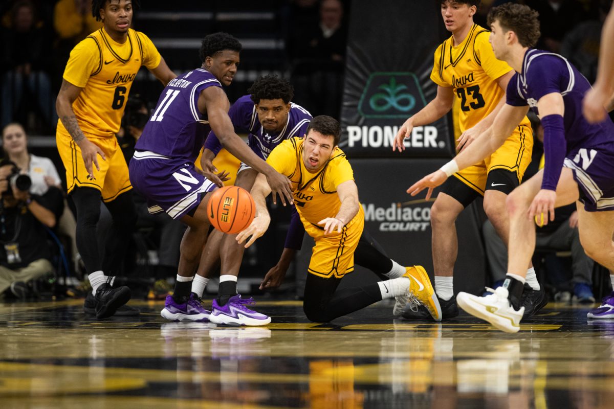 Alvaro Folgueiras dives on the floor to catch the ball during a basketball game between the Iowa Hawkeyes and the Northwestern Wildcats at Carver-Hawkeye Arena on Sunday, Feb. 8, 2026. The Hawkeyes defeated the Wildcats 76-70. (Dexter Westbay/The Daily Iowan)
