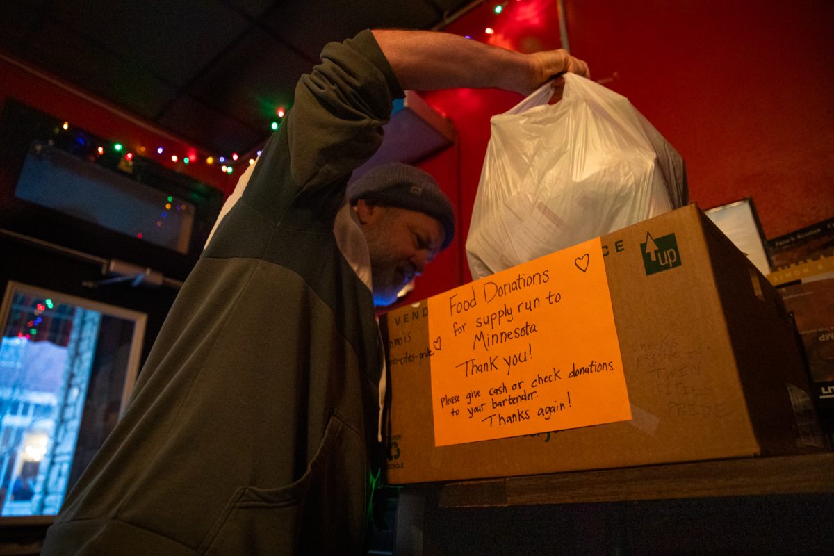 Charlie Morris looks through a donation box at George’s Buffet in Northside Iowa City on Monday, Feb. 9, 2026. George’s is one of multiple Northside businesses that has created a donation bin of aid to be driven to Minneapolis. (Ava Neumaier / The Daily Iowan)