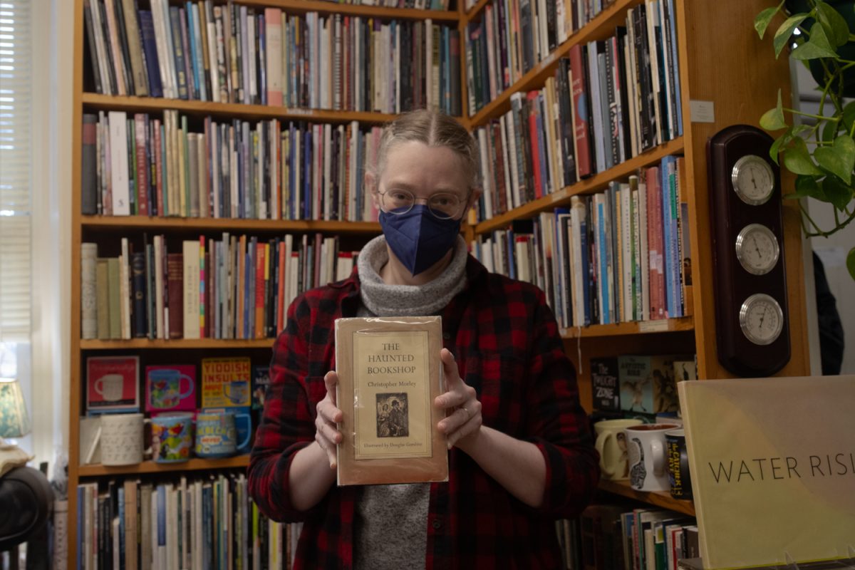 The Haunted Bookshop owner holds the book the show was named after at the Haunted Bookshop in Iowa City, Iowa, on Tuesday, Feb. 10, 2026