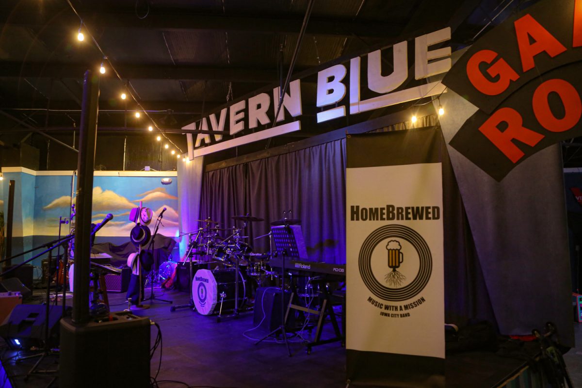 The band HomeBrewed sports their logo “music with a mission” while preforming at Tavern Blue in Iowa City on Feb. 15, 2026.