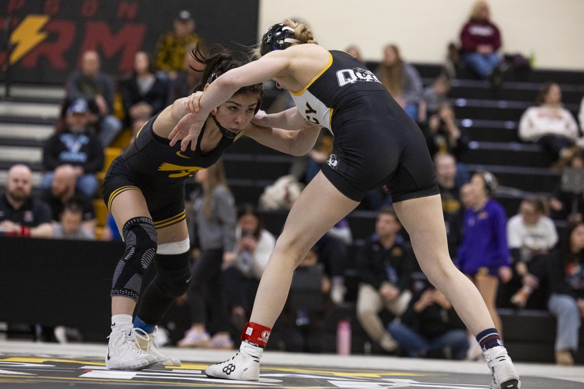 Iowa 110 pounder Nyla Valencia grabs the arm of Quincy 110 pounder Alexandra Tchekounova in her semifinal match on the second day of NCAA Regionals in the Cowles Field House at Simpson College in Indianola on Saturday, Feb. 21, 2026. Valencia won this match 10-0 by technical fall to go to the 1st place match. Every Iowa wrestler made it to the 1st place match, sweeping the semifinal round. (Travis Crabb/The Daily Iowan)
