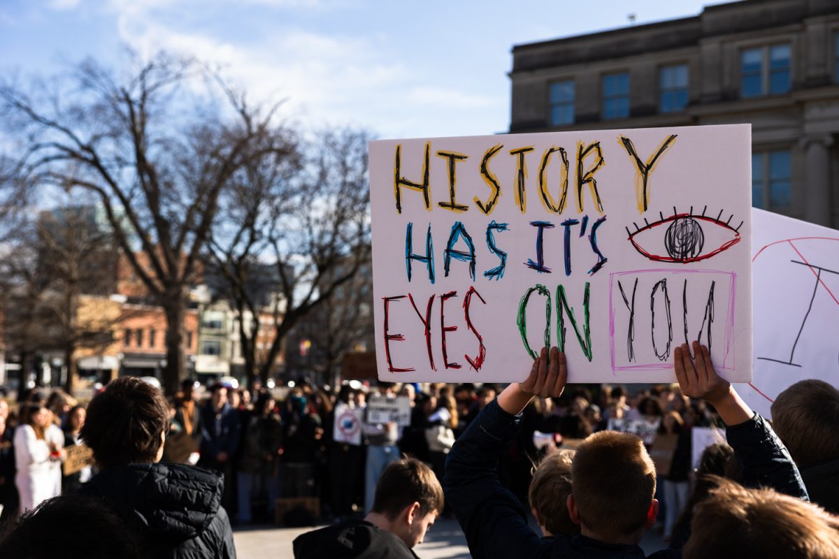A protester holds a sign during a protest against ICE at the Pentacrest in Iowa City on Thursday, Feb. 5, 2026. The protest was made up of mostly high-school and middle-school aged students. (Liz Sleper/The Daily Iowan)