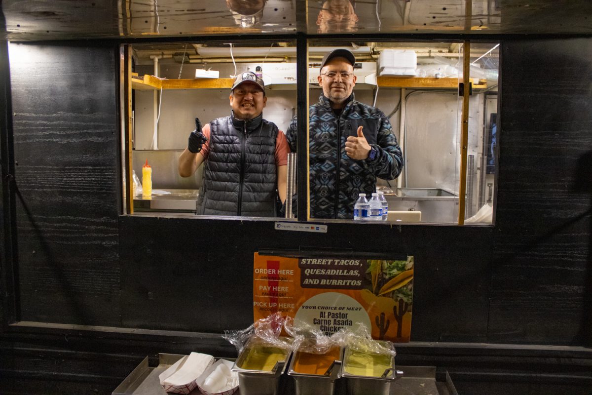 Cactus cooks Iban and Raoul pose for a portrait at an outdoor stand on the Pedestrian Mall in Iowa City, IA on Friday, Feb. 27, 2026. Cactus is one of many businesses that brave cold weather to serve food until bars close downtown.