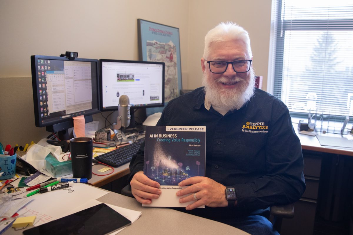 University of Iowa Tippie College of Business Associate Professor Patrick Johanns poses for a portrait with his newly published textbook, "AI in Business: Creating Value Responsibly" on March 5 in Iowa City. The book will educate readers on how to ethically use artificial intelligence in the business world.