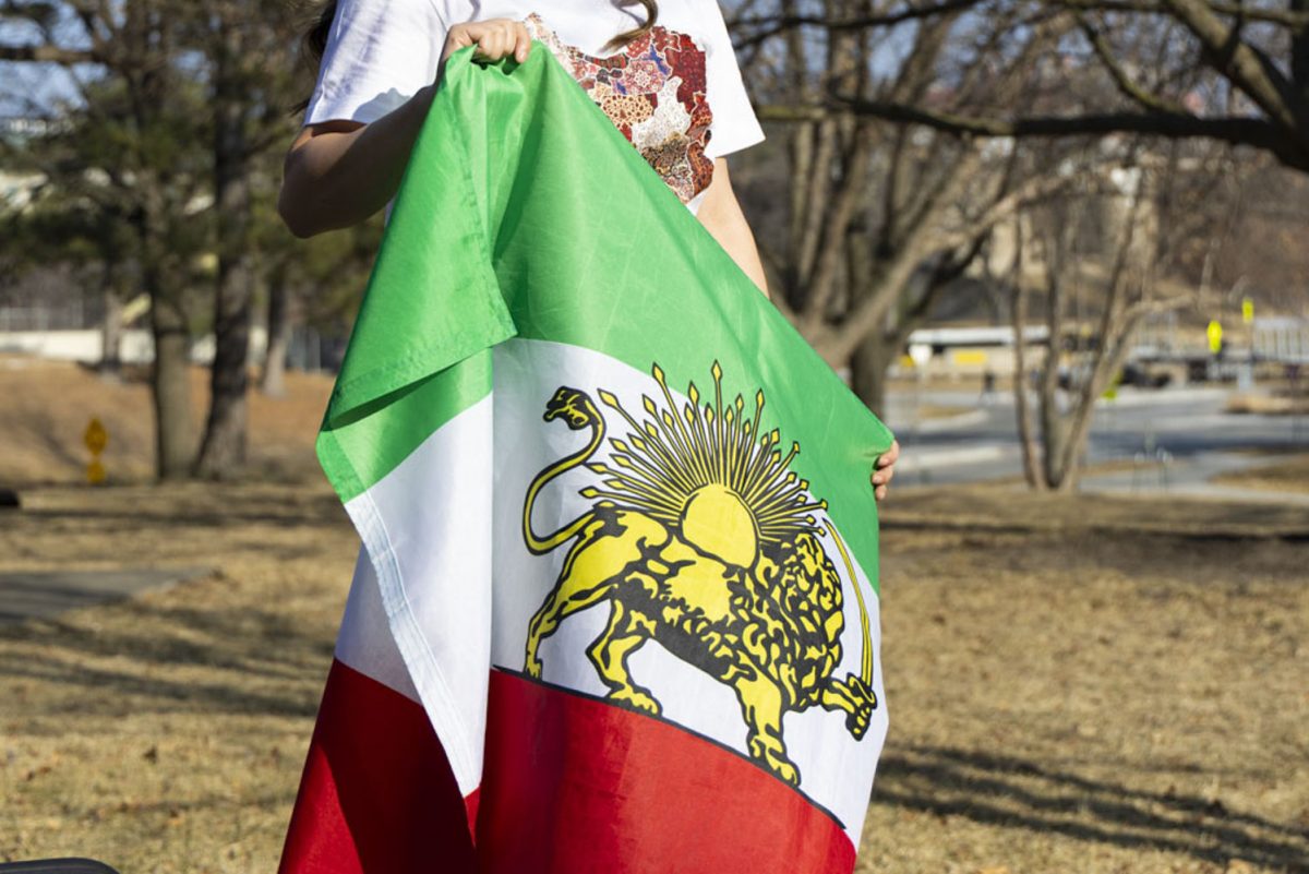 A students holds an Iranian flag on Friday, March 6, 2026. (Samantha DeFily/The Daily Iowan)