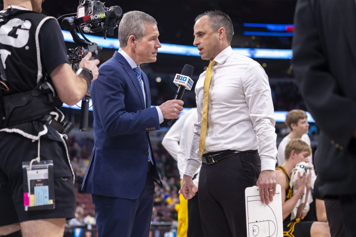 Iowa head coach Ben McCollum speaks with sideline reporter Rick Pizzo during a basketball game between the No. 9 seed Iowa Hawkeyes and the No. 8 seed Ohio State Buckeyes at the United Center in Chicago, Illinois on Thursday, March 12, 2026. The Buckeyes defeated the Hawkeyes, 72-69. (Samantha DeFily/The Daily Iowan)